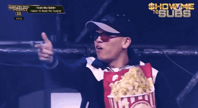 A Man Is Holding A Bag Of Popcorn In Front Of A Sign That Says Show Me The Subs GIF