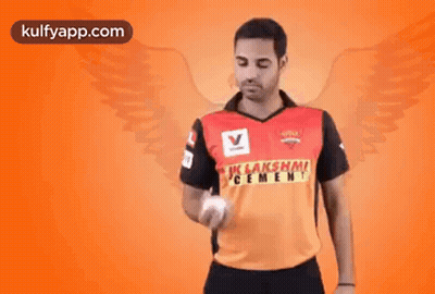 A Man Is Holding A Ball In His Hand And Wearing A Shirt That Says ' Lakshmi Cement ' On It . GIF