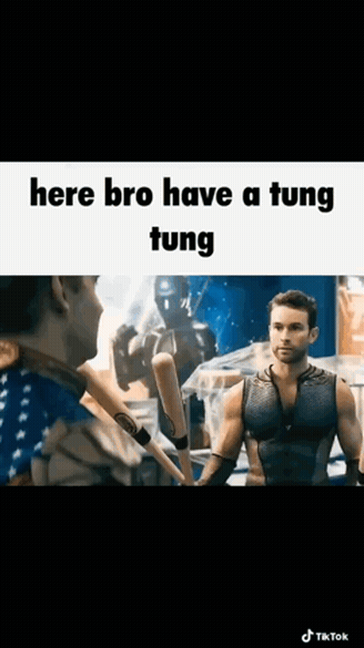 A Man Is Holding A Baseball Bat And Talking To Another Man In A Boxing Ring . GIF