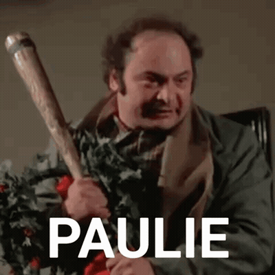 A Man Is Holding A Baseball Bat In His Hand With The Name Paulie Written On It . GIF