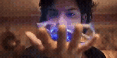 A Man Is Holding A Blue Object In His Hands GIF