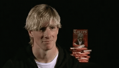 A Man Is Holding A Book Titled Torres GIF