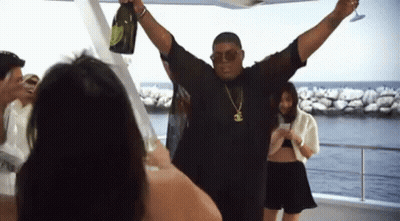 A Man Is Holding A Bottle Of Champagne And A Glass GIF