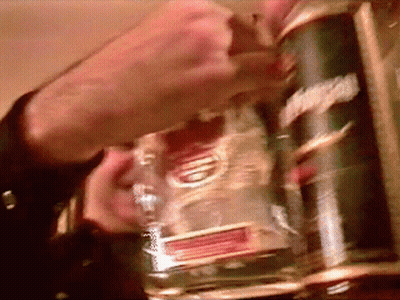 A Man Is Holding A Bottle Of Smirnoff Vodka In His Hand GIF