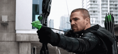 A Man Is Holding A Bow And Arrow With A Green Arrow . GIF