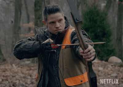 A Man Is Holding A Bow And Arrow With A Netflix Logo In The Background GIF