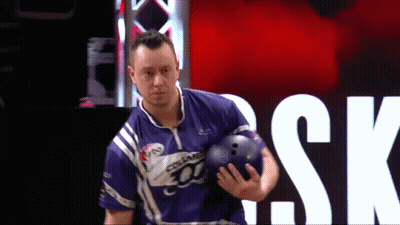 A Man Is Holding A Bowling Ball In Front Of A Sign That Says " Sk " GIF