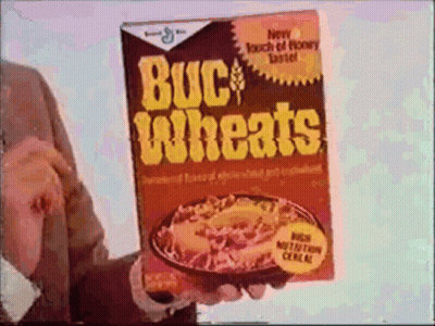A Man Is Holding A Box Of Buckwheats Cereal In His Hand GIF