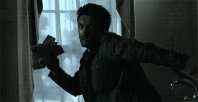 A Man Is Holding A Bunch Of Money In His Hand While Looking Out Of A Window . GIF