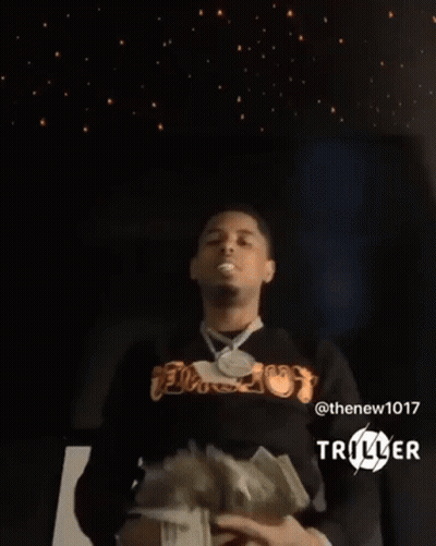 A Man Is Holding A Bunch Of Money In His Hands In Front Of A Starry Sky . GIF