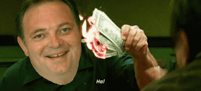 A Man Is Holding A Burning Dollar Bill In His Hand And Smiling At Another Man . GIF