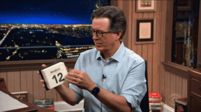 A Man Is Holding A Calendar That Says March 12 On It GIF