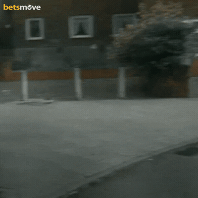A Man Is Holding A Camera In Front Of A Building With The Words Betsmove On The Bottom GIF