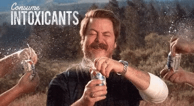 A Man Is Holding A Can Of Beer In Front Of His Face While Being Sprayed With A Can Of Beer . GIF