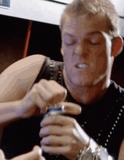 A Man Is Holding A Can Of Soda In His Hand And Making A Face . GIF