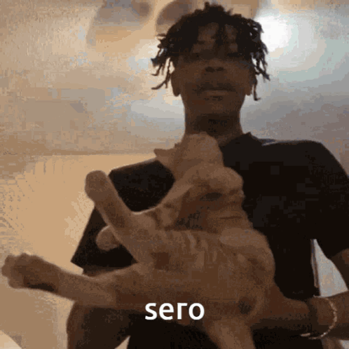 A Man Is Holding A Cat In His Arms And The Word Sero Is On The Bottom GIF
