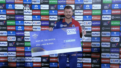 A Man Is Holding A Cheque That Says Man Of The Match On It GIF