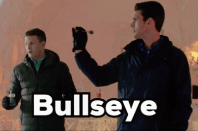 A Man Is Holding A Dart In His Hand And The Word Bullseye Is On The Bottom GIF