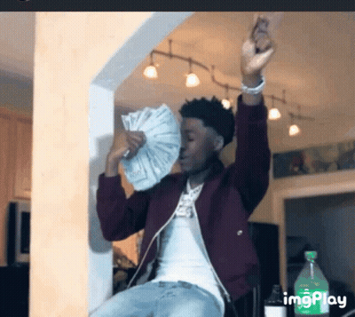 a man is holding a fan of money in his hand .