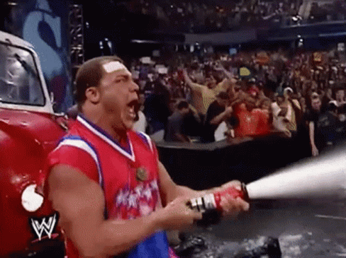 A Man Is Holding A Fire Extinguisher In Front Of A W Logo On The Back Of A Truck GIF