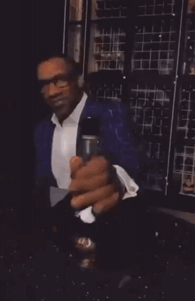 A Man Is Holding A Glass And A Bottle Of Wine GIF