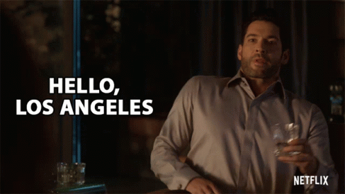 A Man Is Holding A Glass Of Whiskey And Saying Hello Los Angeles GIF