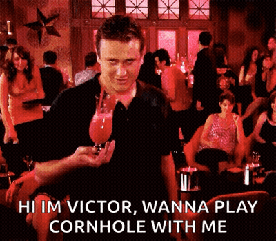 A Man Is Holding A Glass Of Wine And Says Hi Im Victor Wanna Play Cornhole With Me . GIF