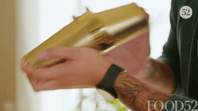 A Man Is Holding A Gold Shaker With The Number 52 On His Shirt GIF