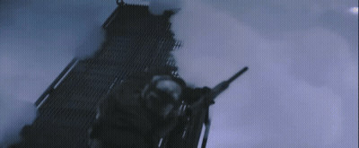 A Man Is Holding A Gun In A Dark Room With Smoke Coming Out Of It GIF