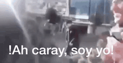 A Man Is Holding A Gun In A Room With The Words `` Ah Caray , Soy Yo '' Written On The Bottom . GIF