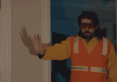 A Man Is Holding A Gun In Front Of A Door That Says Focus GIF