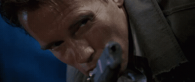 A Man Is Holding A Gun In His Mouth GIF