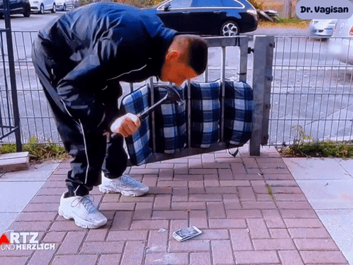 Man Holding Hammer In Front Of Dr. Vagin Sign GIF