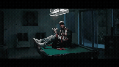 A Man Is Holding A Large Stack Of Money In His Hand . GIF