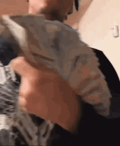 A Man Is Holding A Large Stack Of Money In His Hands . GIF