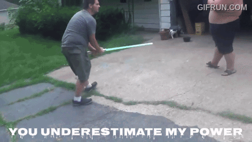 A Man Is Holding A Light Saber While Another Man Stands Behind Him With The Words You Underestimate My Power Below Him GIF