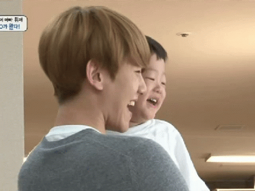A Man Is Holding A Little Boy In His Arms And Laughing GIF