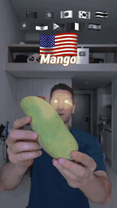 A Man Is Holding A Mango In Front Of A Flag That Says Mango GIF