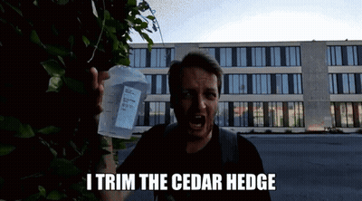 A Man Is Holding A Measuring Cup And Saying " I Trim The Cedar Hedge " In Front Of A Building GIF