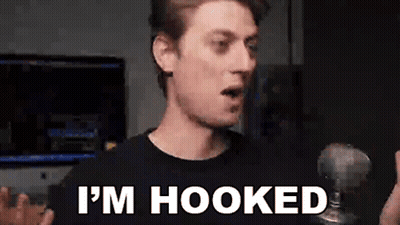 A Man Is Holding A Microphone And Saying `` I 'M Hooked '' GIF