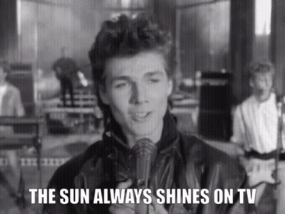 A Man Is Holding A Microphone And Singing Into It In A Black And White Photo . GIF