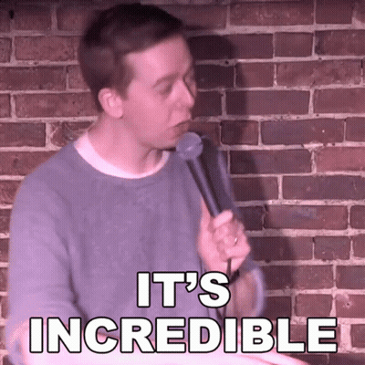A Man Is Holding A Microphone In Front Of A Brick Wall And Says " It 'S Incredible " GIF