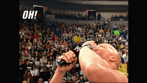 A Man Is Holding A Microphone In Front Of A Crowd And The Words Oh Are Visible GIF