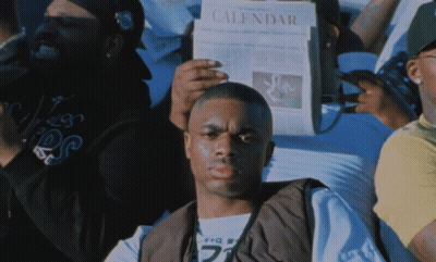 A Man Is Holding A Newspaper That Says Calendar GIF