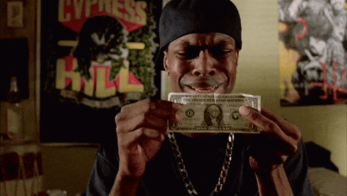 A Man Is Holding A One Dollar Bill In Front Of A Poster That Says Cypress Hill GIF