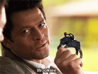 A Man Is Holding A Pair Of Handcuffs And Saying Wookiee GIF
