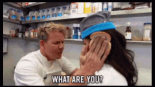 A Man Is Holding A Piece Of Bread Over A Woman 'S Ear And Says What Are You GIF