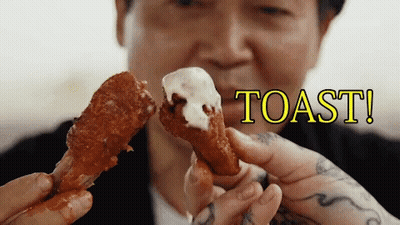 A Man Is Holding A Piece Of Chicken With The Word Toast Written Above It GIF