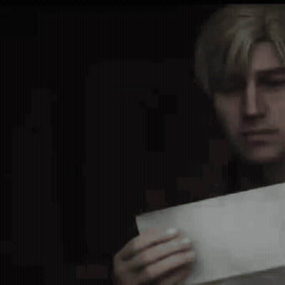 A Man Is Holding A Piece Of Paper In His Hand And Looking At It . GIF