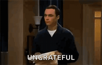 A Man Is Holding A Piece Of Paper In His Hands And The Word Ungrateful Is On The Screen . GIF